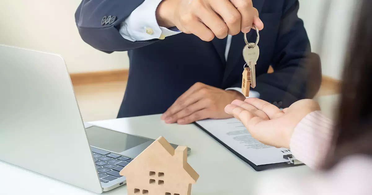 A person handing over keys to another person