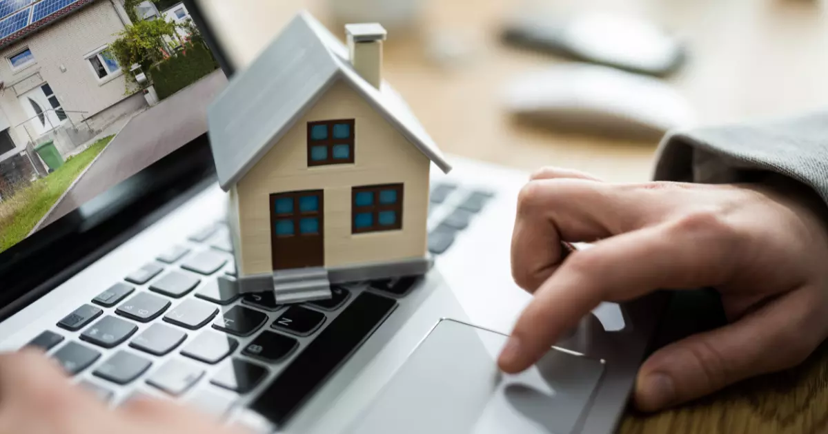 A person's hand on a computer keyboard with a small house on it