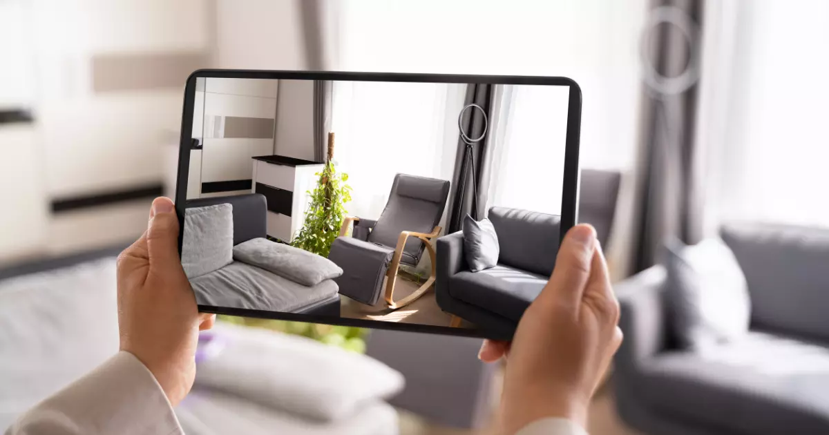 A person holding a tablet with a picture of a couch and a chair 