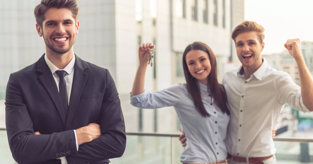 A group of people posing for a photo where a woman is holding keys